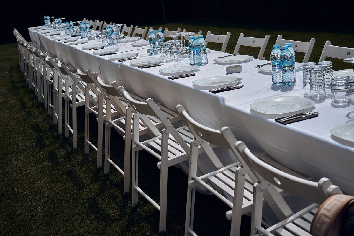 Елегантно подредена маса с бели покривки на вечерно събитие